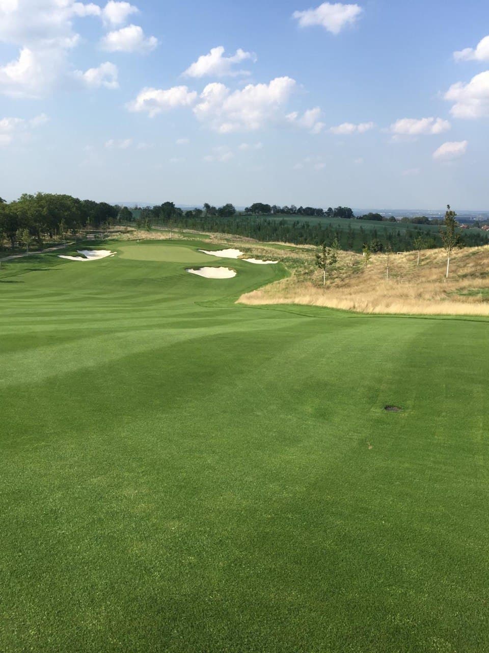 Dokončené golfové hřiště OAKS s fairwayí, greenem a pískovými bunkery