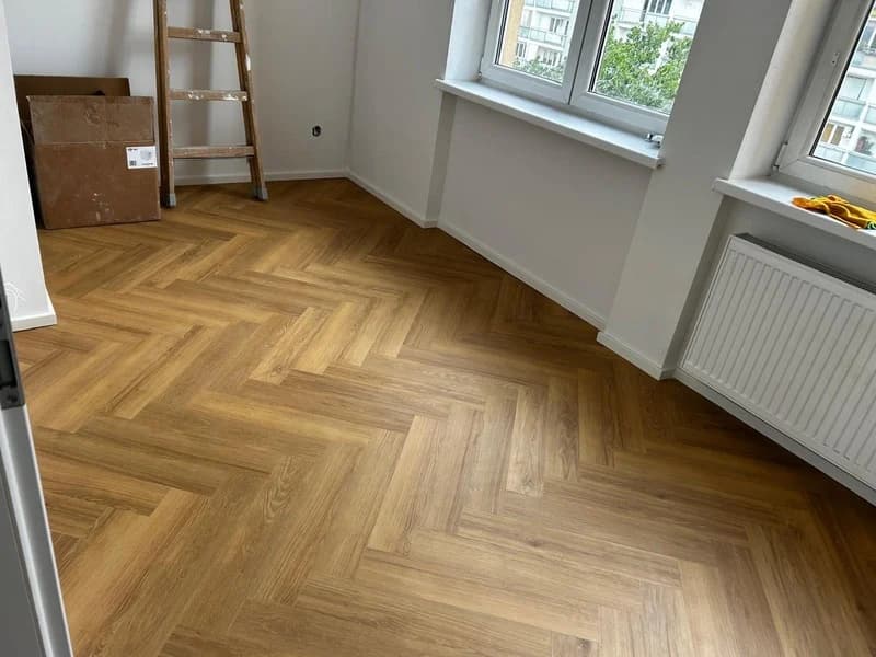 Detail položené vinylové podlahy ve vzoru rybí kosti
