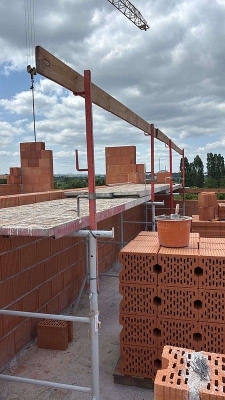 Lešení a palety keramických tvárnic na stavbě bytového domu